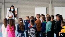 Arhiva - Nastavnica i đaci u osnovnoj školi u predgrađu Beograda, 1. septembra 2021.