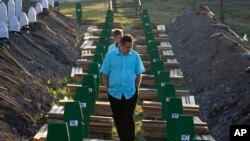 បុរស​បូស្ន៊ី​ម្នាក់​ដើរ​កាត់​ផ្នូរ​សព​ កំឡុង​ពិធី​បុណ្យ​សម្រាប់​ជន​រងគ្រោះ​១៣៦នាក់​នៅ​ក្រុង​ Srebrenica ១៥០គ.ម.​ពី​ក្រុង Sarajevo​ ប្រទេស​បូស្ន៊ី កាលពី​ថ្ងៃទី១១ ខែកក្កដា ឆ្នាំ២០១៥។