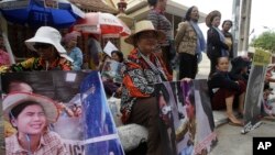 A Boeung Kak lake community's land activist, left, holds a poster of detained Tep Vanny as she joins together with the others to deliver petition to the Justice Ministry, in Phnom Penh, Cambodia, Wednesday, Jan. 4, 2017. The villagers of Boeung Kak lake community staged a protest to demand the release of detained land rights activist Tep Vanny, who was sentenced last August to six months in prison. Phnom Penh's Boueng Kak is a lake area the government awarded to a Chinese company for commercial development, including a hotel, office buildings and luxury housing. (AP Photo/Heng Sinith)