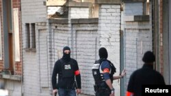 La Police sur les lieux où les tirs ont été tirés lors d'une perquisition de la police d'une maison dans la banlieue de Forest , près de Bruxelles , en Belgique , le 15 Mars 2016.