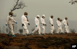 Members of the California Army National Guard search a property for human remains at the Camp fire, Nov. 14, 2018, in Paradise, Calif.