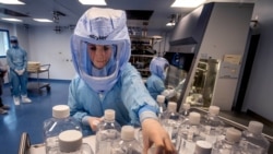 FILE - A laboratory worker simulates the workflow in a cleanroom of the BioNTech Corona vaccine production facility in Marburg, Germany, during a media day, March 27, 2021.