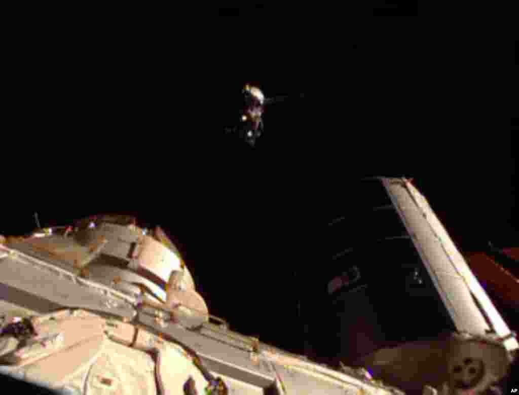 This image taken from video provided by NASA shows the Soyuz carrying three new Expedition 36 crew members, top, approaching the International Space Station, May 29, 2013.