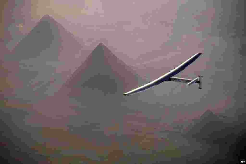 This handout photo released by Solar Impulse 2 shows the solar powered plane, piloted by Swiss pioneer André Borschberg, during the flyover of the pyramids of Giza, July 13, 2016 prior to landing in Cairo, Egypt.