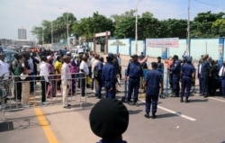 FILE - Congolese police officers control civilians during a total lockdown amid concerns about the spread of the coronavirus disease (COVID-19), in Gombe commune of Kinshasa, DRC, April 6, 2020.