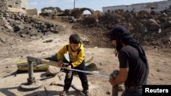 Wasu fararen hula suna gyara bututun ruwa da aka lalata lokacin yaki da yanzu ana iya gyarawa saboda tsagaita wuta