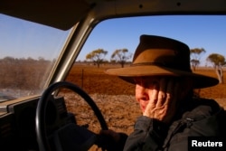 Farmer May McKeown reacts as she drives her truck to feed the remaining cattle on her drought-affected property, located on the outskirts of the north-western New South Wales town of Walgett, in Australia, July 20, 2018.