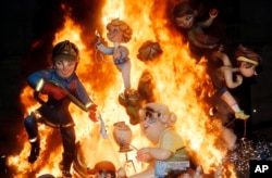 FILE - Statues burn during the traditional Fallas festival in Valencia, Spain, on March 19, 2014. Every year the city of Valencia celebrates the ancient "Las Fallas" fiesta,