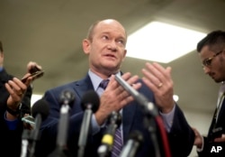 FILE - Sen. Chris Coons, a Delaware Democrat, gestures while speaking to reporters on Capitol Hill in Washington, Nov. 28, 2018.