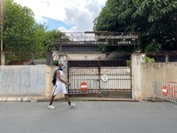 បុរសម្នាក់ដើរកាត់មុខច្រកទ្វារចូលចាស់នៃសារមន្ទីរទួលស្លែង (អតីតមន្ទីរ ស២១) កាលពីថ្ងៃទី០២ ខែកញ្ញា ឆ្នាំ២០២០។ (អូន ឆេងប៉រ/វីអូអេ)