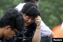 A relative of a passenger of the sunken cruise ship cries on a road to the site of the sinking in the Jianli section of Yangtze River, Hubei province, China, June 3, 2015.