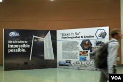 A conference visitor passes a display evoking a “Star Trek” future. The science-fiction show’s hand-held medical scanners don’t exist (yet), but near-instant diagnostic tests for diseases do. (Credit: Art Chimes/VOA)