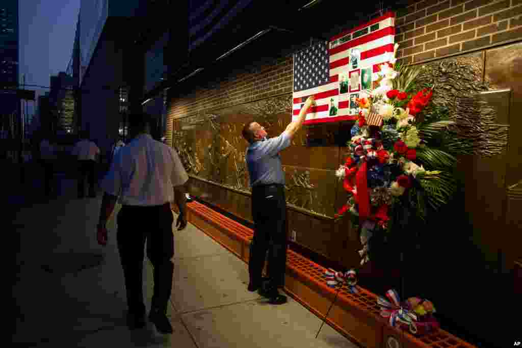 FDNY Firefighter Mike Bellantoni prepares a memento at the Firefighter&#39;s Memorial adjacent to the One World Trade Center, Sept. 11, 2013.