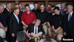 US President Donald Trump reacts after signing an executive order eliminating Obama-era climate change regulations at the Environmental Protection Agency in Washington, March 28, 2017.