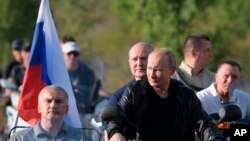Russian President Vladimir Putin drives a motorbike during the Babylon's Shadow bike show camp near in Sevastopol, Crimea, Aug. 10, 2019. 