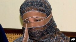 FILE - Pakistani Christian woman Asia Bibi listens to Governor of Pakistani Punjab Province Salman Taseer, unseen, at a prison in Sheikhupura near Lahore, Nov. 20, 2010. 