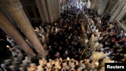 ក្រុម​អ្នក​កាន់​គ្រិស្ត​សាសនា​និកាយ​កាតូលិក​កាន់​ទៀន​ក្នុង​អំឡុង​ពេល​ប្រារព្ធ​ពិធី​បុណ្យ​ព្រះ​យេស៊ូ​មាន​ព្រះជន្ម​រស់​នៅ​ក្នុង​​ព្រះវិហារ​គ្រិស្ត​សាសនា​ Holy Sepulcher ទីក្រុង​ហ្ស៊េរុយសាឡិម​កាល​ពី​ថ្ងៃ​ទី​៥​ ខែ​មេសា​ ឆ្នាំ​២០១៥។