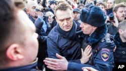 In this photo provided by Evgeny Feldman, Alexei Navalny is detained by police in downtown Moscow, Russia, March 26, 2017. 