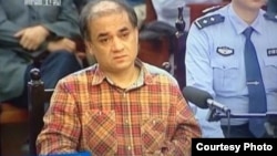 新疆电视播出伊力哈木在乌鲁木齐出庭新闻图像。(微博图片)