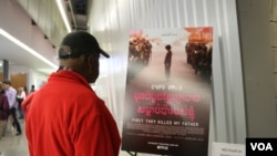 ជនបរទេស​ម្នាក់​មើលផ្ទាំង​ផ្សព្វផ្សាយ​ភាពយន្ត «មុនដំបូងខ្មែរក្រហមសម្លាប់ប៉ារបស់ខ្ញុំ» នៅ​ក្រុង​ Silver Spring រដ្ឋ Maryland កាល​ពី​ថ្ងៃទី២០ ខែតុលា ឆ្នាំ២០១៧។ (ណឹម សុភ័ក្រ្តបញ្ញា/ VOA) 