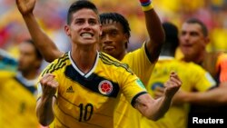 James Rodriguez (kiri) dan Juan Cuadrado dari Kolombia merayakan kemenangan atas Pantai Gading dalam Piala Dunia 2014 di Brasilia (19/6). (Reuters/Paul Hanna)