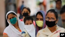 People wait in line at a coronavirus testing site in Prayagraj, India, Sept. 5, 2020. 