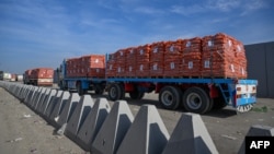Truk-truk yang membawa bantuan menunggu untuk menyeberang ke Gaza dari sisi Mesir di perbatasan Rafah, 19 Januari 2025. (Khaled DESOUKI / AFP)
