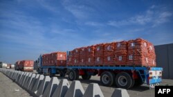 FILE - Trucks loaded with aid wait to cross into Gaza from the Egyptian side of the Rafah border crossing on Jan. 19, 2025.