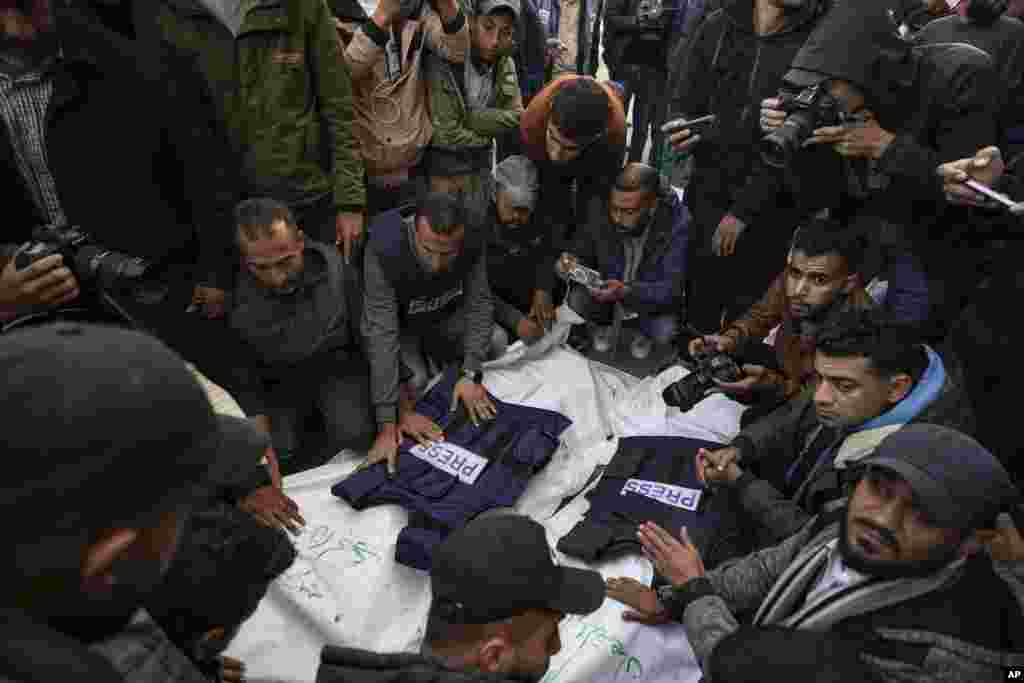 Palestinians, mostly journalists, gather around the bodies of five Palestinian journalists who were killed by an Israeli airstrike in Gaza City, at the Al-Aqsa Hospital in Deir al-Balah.