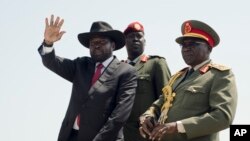 FILE - South Sudan's President Salva Kiir, left, accompanied by army chief of staff Paul Malong Awan, waves during an independence day ceremony in the capital Juba, South Sudan, July 9, 2015. 