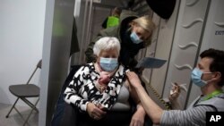 FILE - A woman receives a dose of the AstraZeneca COVID-19 vaccine at the Vaccine.