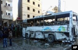 In this photo released by the Syrian official news agency SANA, Syrians gather where three bombs exploded in Sayyda Zeinab, a predominantly Shiite Muslim suburb of the Syrian capital, Syria, Jan. 31, 2016.