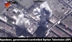 FILE - This image made from video of drone footage allegedly showing Syrian army airstrikes targeting Zahran Allouch, the head of the Army of Islam group near Damascus, Syria, Dec. 25, 2015.