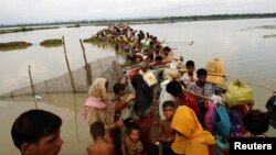 FILE - Rohingya refugees wait for boats to cross a canal after crossing the border through the Naf river in Teknaf, Bangladesh, Sept. 7, 2017.