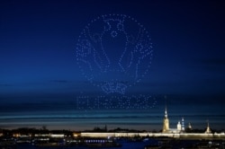 Drone yang membentuk logo Piala Eropa UEFA 2020 menerangi langit di atas Katedral Santo Petrus dan Paulus di Saint Petersburg, Rusia 2 Mei 2021. (Foto: Reuters)