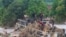 In this still image from video, people stand on an overturned vehicle that was swept away by floodwaters, in Chikwawa, Malawi, Jan. 25, 2022. 