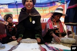 FILE - Aymara indigenous women grind grains of quinoa in Oruro, Bolivia, in 2013.