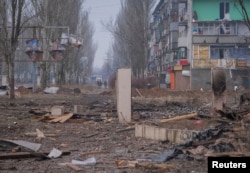 Ukrainian service members are seen an empty street in Bakhmut