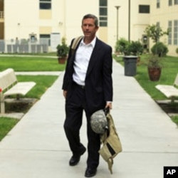 An unidentified US Embassy employee in Kabul carries a helmet and body armor following Taliban attacks on the compound, September 14, 2011.