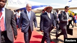 Israeli Prime Minister Benjamin Netanyahu (L) walks with Uganda's President Yoweri Museveni (R) after arriving to commemorate the 40th anniversary of Operation Entebbe at the Entebbe airport in Uganda, July 4, 2016.