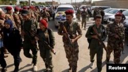 FILE - Fighters of Syrian Democratic Forces (SDF) take part in a funeral procession for comrades killed during clashes in the northeastern Syrian town of Ras al-Ayn, in the town of Qamishli, Syria, Oct, 22, 2019.
