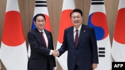 윤석열 한국 대통령과 기시다 후미오 일본 총리가 5월 26일 한국 대통령실에서 가진 정상회담에 앞서 악수하고 있다.