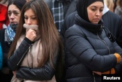 People observe a minute of silence at a street memorial to victims of Tuesday's bombings in Brussels, Belgium, March 24, 2016.