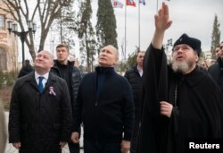 Presiden Rusia Vladimir Putin dan Gubernur Sevastopol Mikhail Razvozhayev (kiri) mengunjungi museum negara "Tauric Chersonese" di Sevastopol, Krimea, 18 Maret 2023.