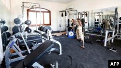 A member of the Fajr Libya (Libya Dawn) Islamist militia stands at the gym of a villa at the U.S. diplomatic compound after members of the group moved into the complex of several villas in southern Tripoli to prevent it from being looted, Aug. 31, 2014.