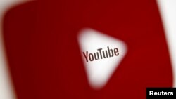 FILE - A 3-D-printed YouTube icon is seen in front of a displayed YouTube logo in this illustration taken Oct. 25, 2017. 