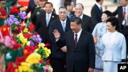 Chinese President Xi Jinping, front left, and his wife Peng Liyuan, front right, wave after arriving at Macao Airport, Dec. 18, 2019.