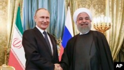 Le président russe Vladimir Poutine serre la main du président iranien Hassan Rohani lors d'un meeting à Moscou le 28 mai 2017
