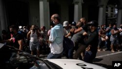 Polisi menahan seorang demonstran anti-pemerintah dalam aksi protes di Havana, Kuba, Minggu 11 Juli 2021. (AP Photo/Ramon Espinosa)