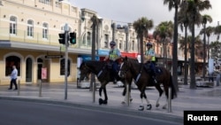 Polisi yang berkuda memantau penerapan "social-distancing" di pinggiran Sydney, selama pandemi Covid-19 di Australia. 